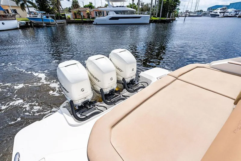 Slide: The Image of 2019 Sea Ray SLX 400 OB with triple outboard engines on a calm waterway. - 22