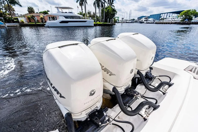 Slide: The Image of 2019 Sea Ray SLX 400 OB with triple Mercury outboard engines on a calm waterfront. - 23