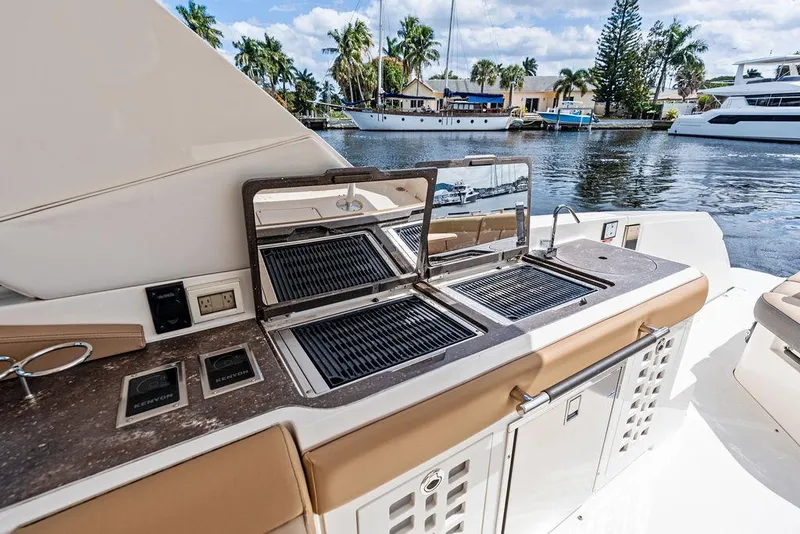Slide: The Image of Outdoor kitchen on 2019 Sea Ray SLX 400 OB yacht with grill and scenic water view. - 27