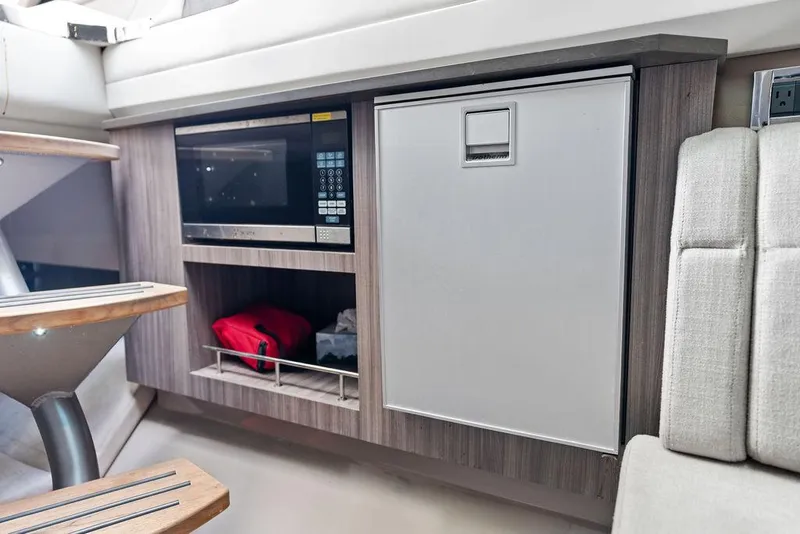 Slide: The Image of 2019 Sea Ray SLX 400 OB interior with microwave and storage cabinet. - 47