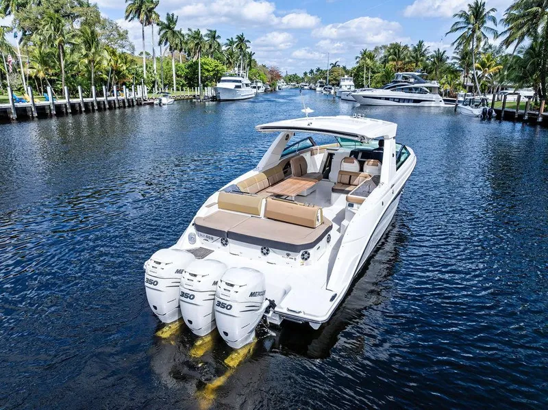 Slide: The Image of 2019 Sea Ray SLX 400 OB cruising on a scenic waterway with palm trees. - 7