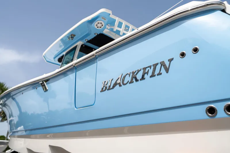 Slide: The Image of 2023 Blackfin 302CC boat, light blue hull, close-up view. - 10