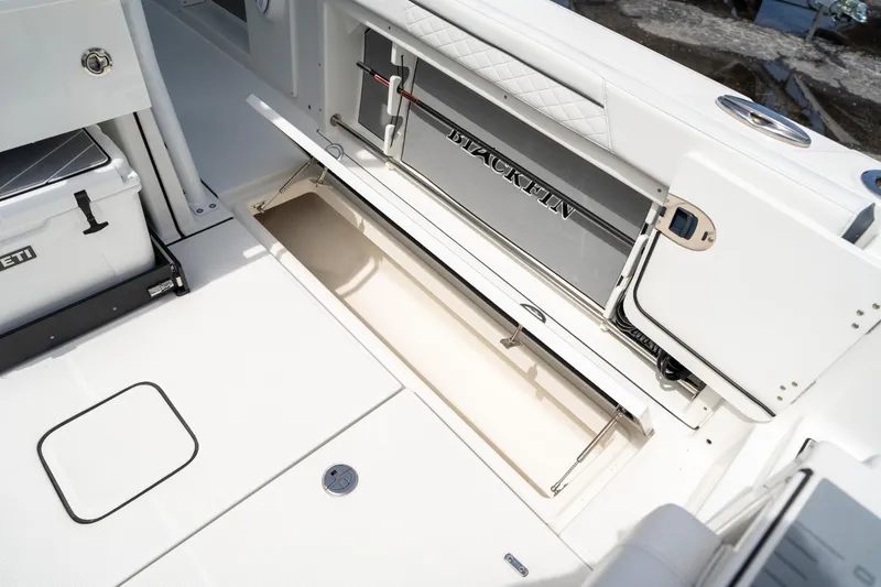 Slide: The Image of 2023 Blackfin 302CC boat interior with open storage compartment and cooler. - 18