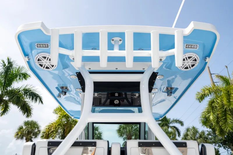 Slide: The Image of 2023 Blackfin 302CC boat with blue canopy and speakers, surrounded by palm trees. - 27