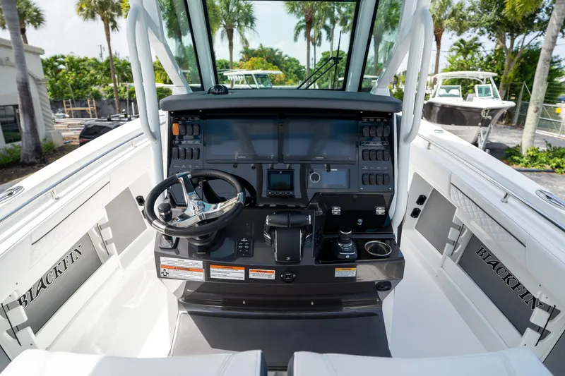 Slide: The Image of 2023 Blackfin 302CC boat cockpit with modern controls and steering wheel. - 32