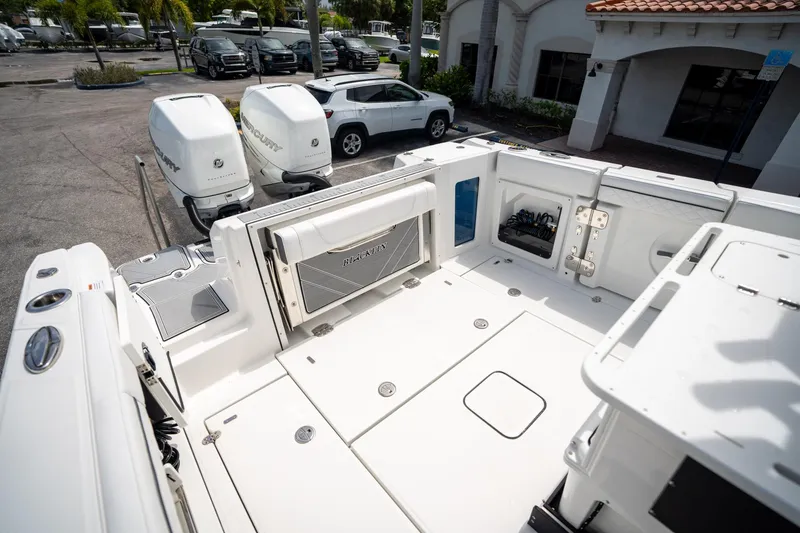 Slide: The Image of 2023 Blackfin 302CC boat deck with twin Mercury engines in a dealership lot. - 14