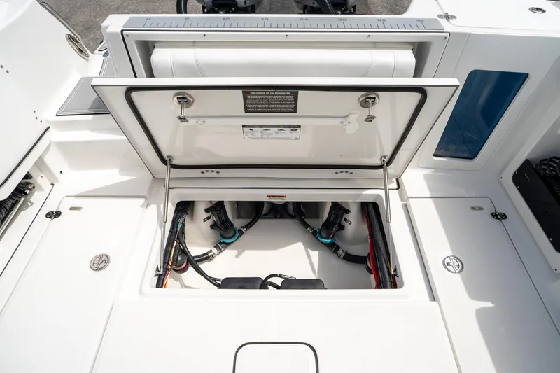 Slide: The Image of 2023 Blackfin 302CC boat storage compartment with open hatch, showcasing internal wiring and components. - 17