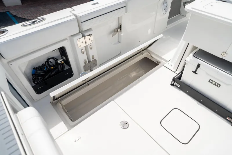 Slide: The Image of 2023 Blackfin 302CC boat interior with storage compartments and Yeti cooler. - 19