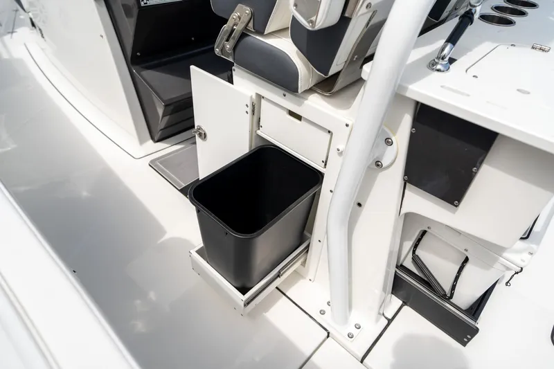 Slide: The Image of 2023 Blackfin 302CC boat interior with open storage compartment and trash bin. - 25
