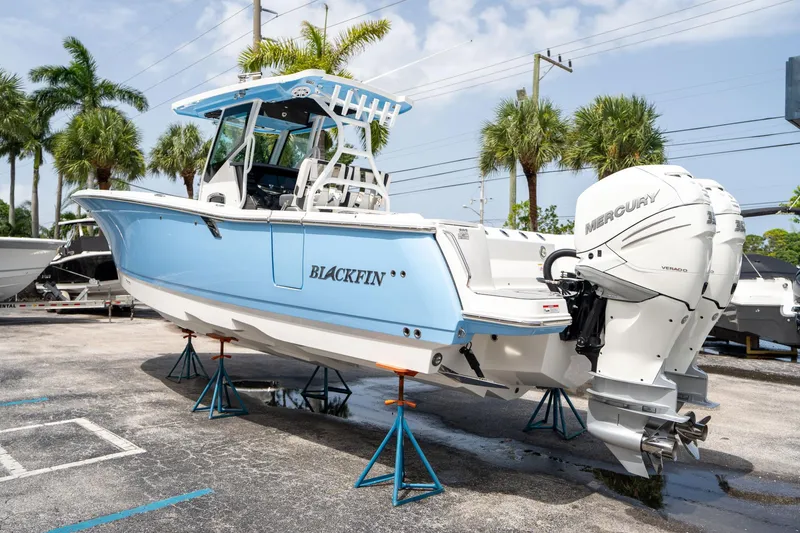 Slide: The Image of 2023 Blackfin 302CC boat with twin Mercury engines on display outdoors. - 4