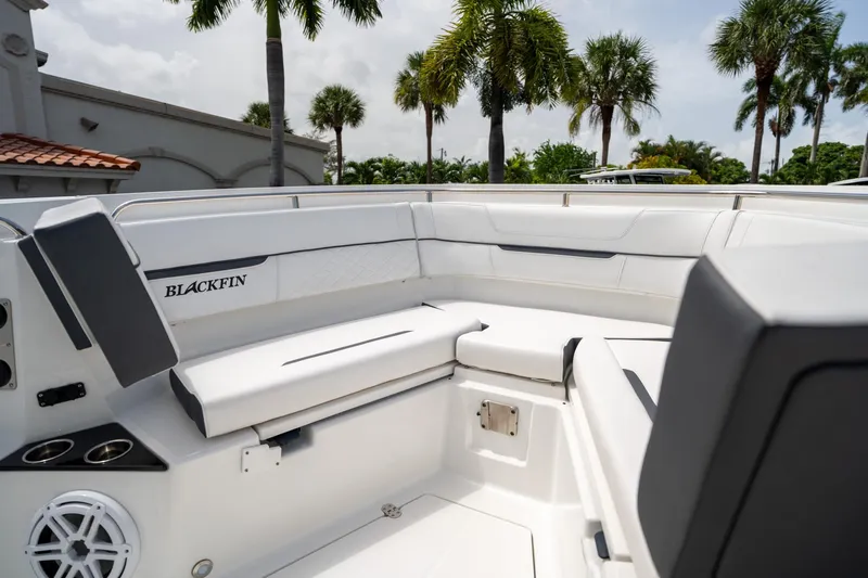 Slide: The Image of 2023 Blackfin 302CC boat interior with seating, palm trees in background. - 45