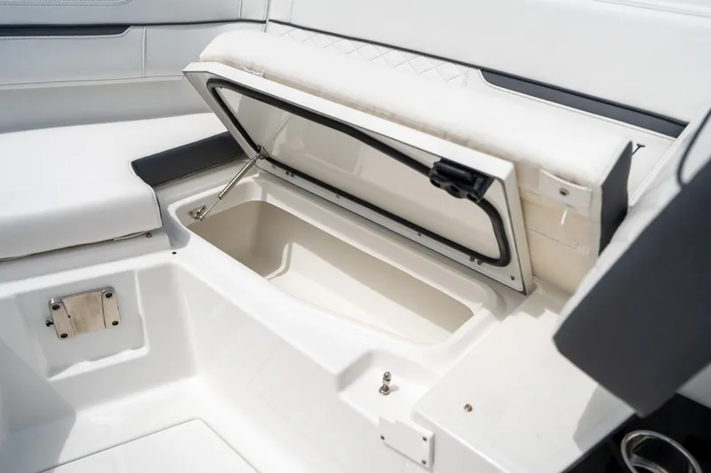 Slide: The Image of 2023 Blackfin 302CC boat storage compartment with open lid, showcasing sleek white interior design. - 48