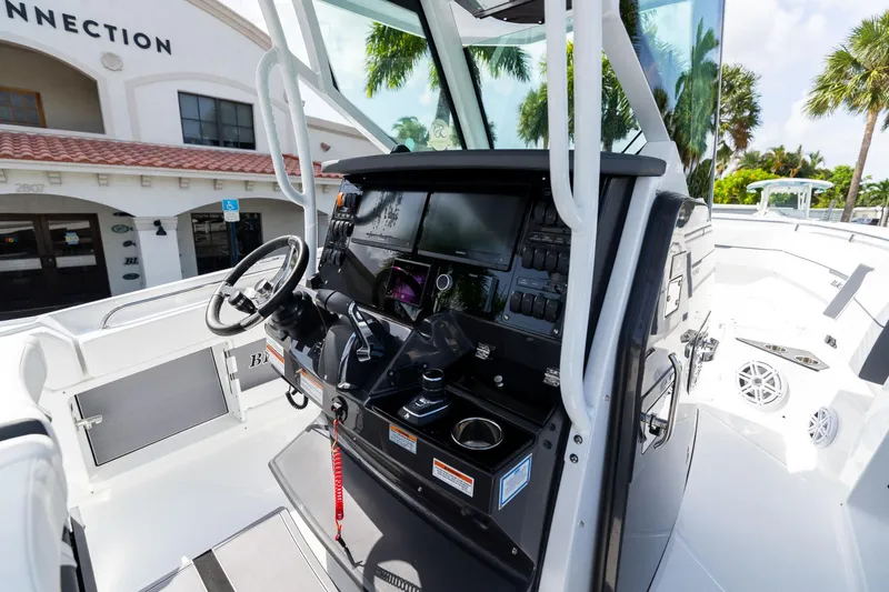 Slide: The Image of 2023 Blackfin 302CC boat cockpit with modern controls and steering wheel. - 28