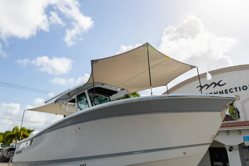 Slide: The Image of 2023 Blackfin 302CC boat with canopy, displayed outdoors under a sunny sky. - 3