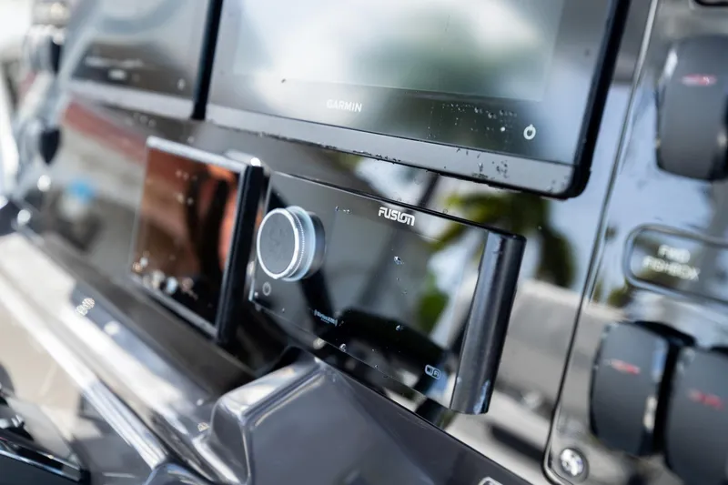 Slide: The Image of Close-up of 2023 Blackfin 302CC boat dashboard with Garmin and Fusion controls. - 31