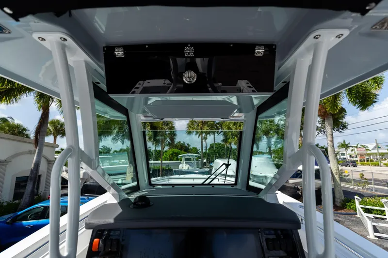 Slide: The Image of 2023 Blackfin 302CC boat interior with modern dashboard and tropical background. - 35