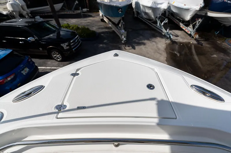 Slide: The Image of 2023 Blackfin 302CC boat bow view in a marina with parked vehicles. - 49