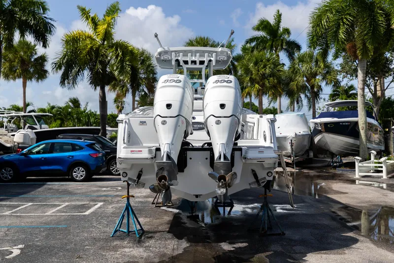Slide: The Image of 2023 Blackfin 302CC boat with twin 400 engines in a marina setting. - 8