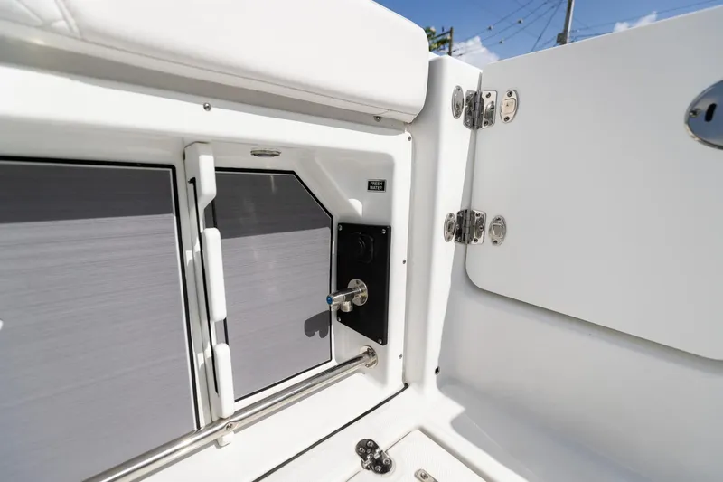 Slide: The Image of 2023 Blackfin 302CC boat interior detail with storage compartment and fresh water access. - 21