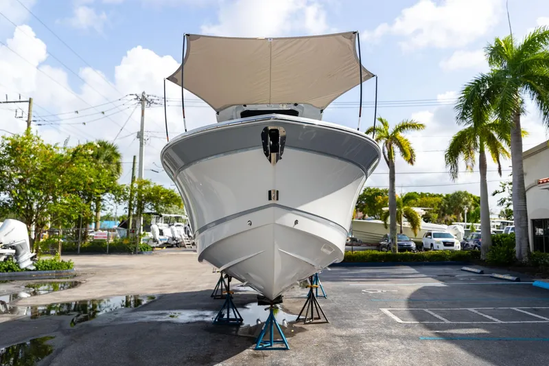 Slide: The Image of 2023 Blackfin 302CC boat on stands, with canopy, in a sunny outdoor setting. - 4
