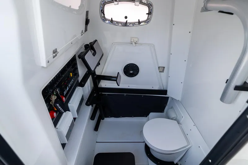 Slide: The Image of Interior of 2023 Blackfin 302CC boat featuring a compact marine toilet and control panel. - 43