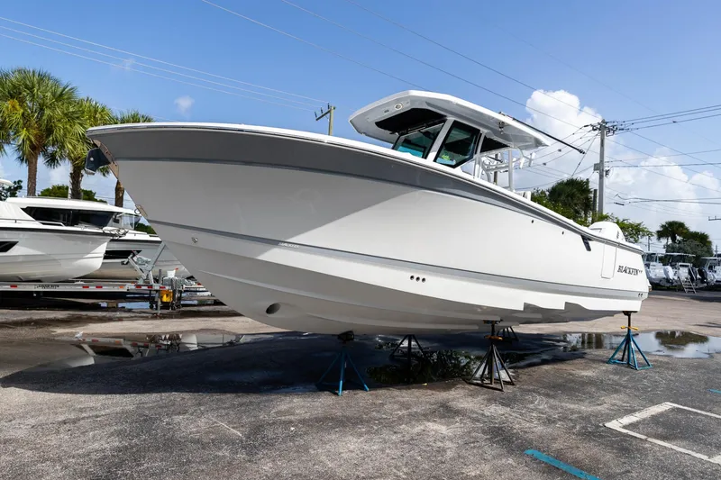 Slide: The Image of 2023 Blackfin 302CC boat on stands in a marina setting. - 5