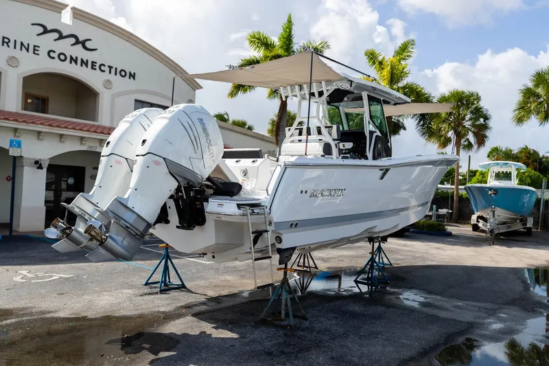 Slide: The Image of 2023 Blackfin 302CC boat on stands at Marine Connection dealership. - 9