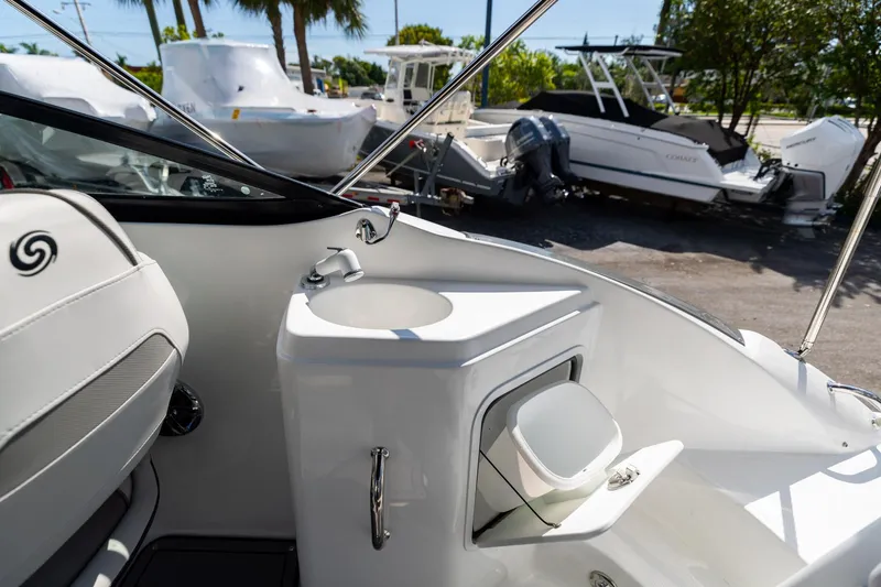 Slide: The Image of 2023 Hurricane SunDeck 2200 OB boat interior with sink and seating area. - 11