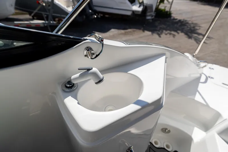 Slide: The Image of 2023 Hurricane SunDeck 2200 OB boat sink detail with faucet, showcasing sleek design. - 12