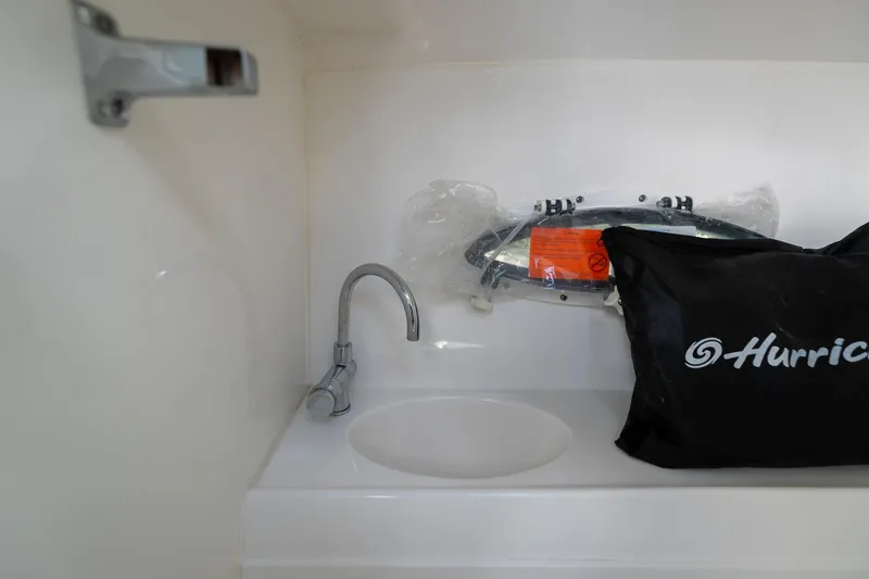 Slide: The Image of Interior of 2023 Hurricane SunDeck 2200 OB boat with sink and branded bag. - 27