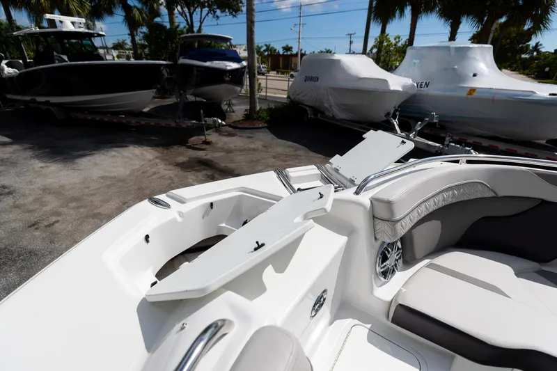 Slide: The Image of 2023 Hurricane SunDeck 2200 OB boat interior with seating, docked alongside other boats. - 36