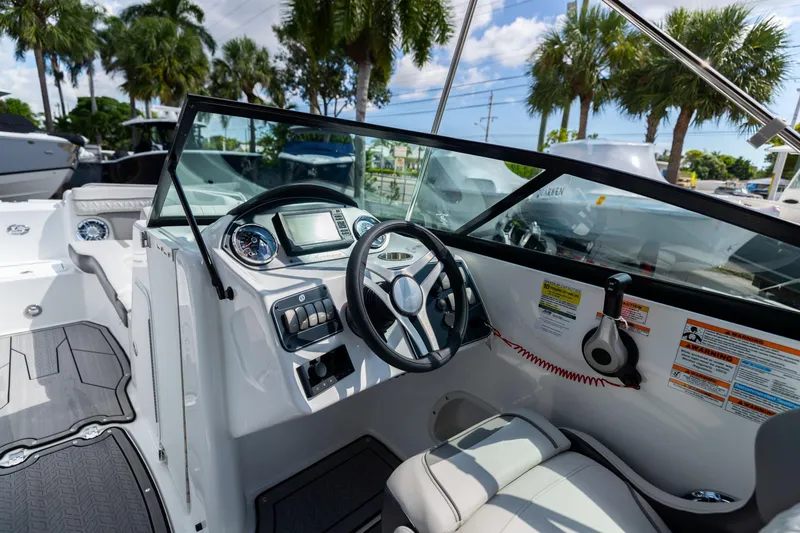 Slide: The Image of 2023 Hurricane SunDeck 2200 OB boat interior with steering wheel and dashboard controls. - 17