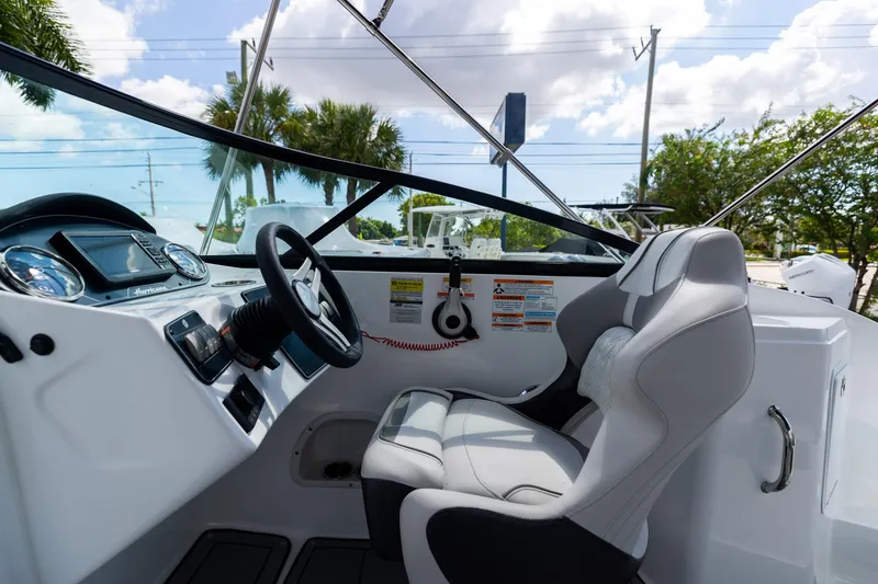 Slide: The Image of 2023 Hurricane SunDeck 2200 OB boat cockpit with steering wheel and comfortable seating. - 18
