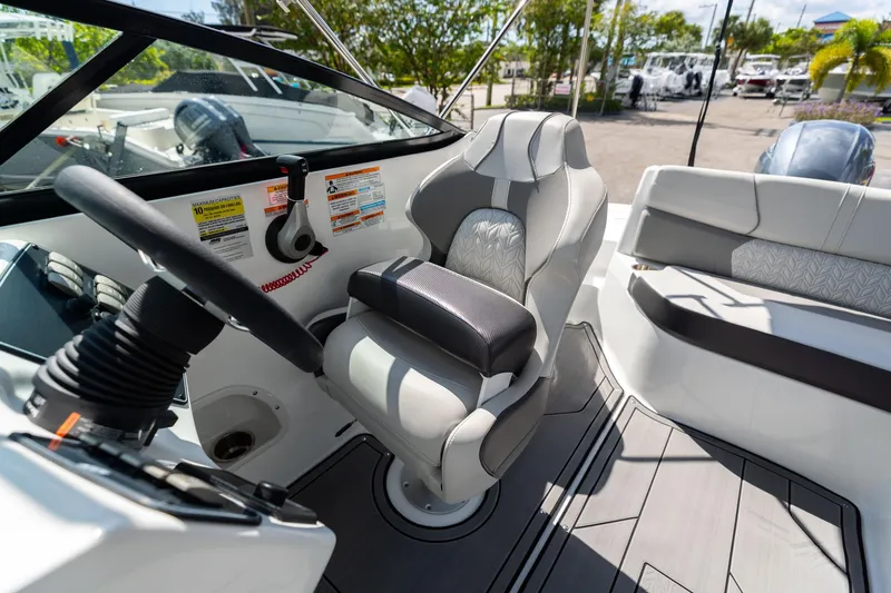 Slide: The Image of 2023 Hurricane SunDeck 2200 OB boat interior with steering wheel and captain's chair. - 23