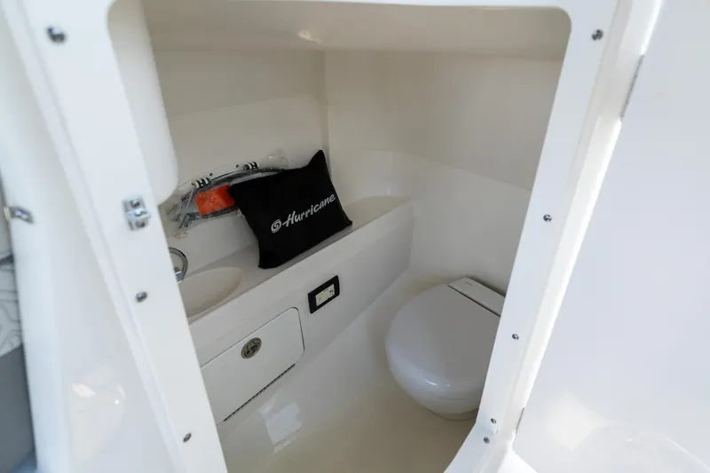 Slide: The Image of Interior of 2023 Hurricane SunDeck 2200 OB boat, featuring a compact marine toilet. - 26