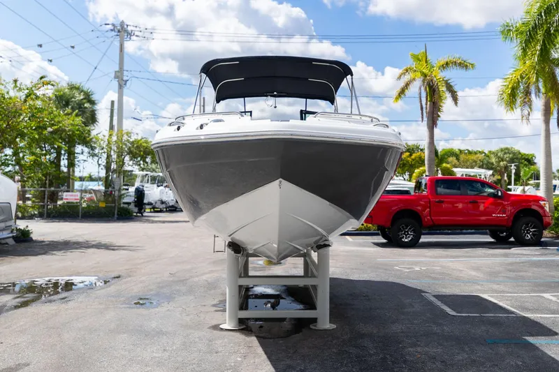 Slide: The Image of 2023 Hurricane SunDeck 2200 OB boat on display, with a red truck in the background. - 3