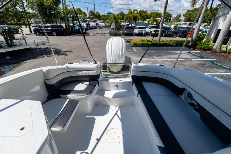 Slide: The Image of 2023 Hurricane SunDeck 2690 OB boat interior with seating, parked outdoors. - 12