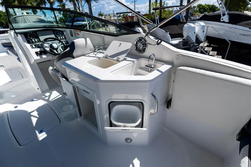 Slide: The Image of 2023 Hurricane SunDeck 2690 OB boat interior with helm and sink area. - 15