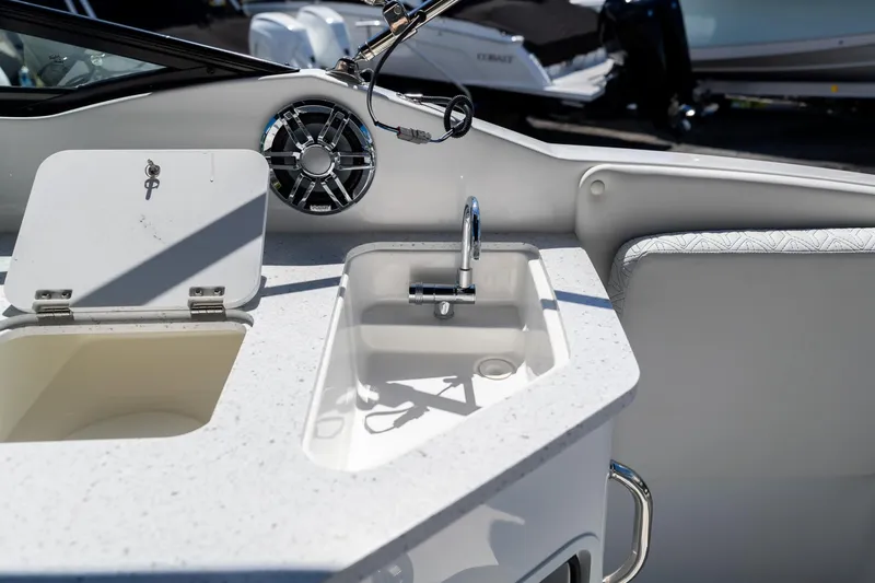 Slide: The Image of 2023 Hurricane SunDeck 2690 OB boat interior with sink and storage compartment. - 16