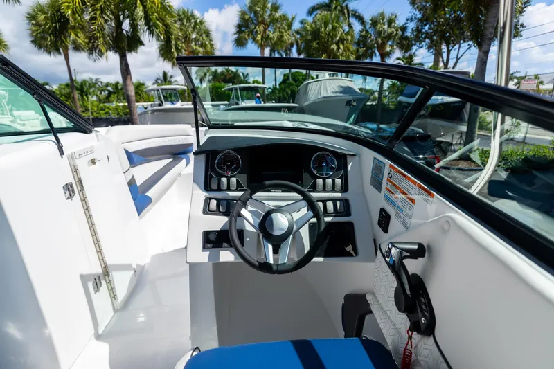 Slide: The Image of 2023 Hurricane SunDeck 2690 OB boat cockpit with steering wheel and dashboard controls. - 17