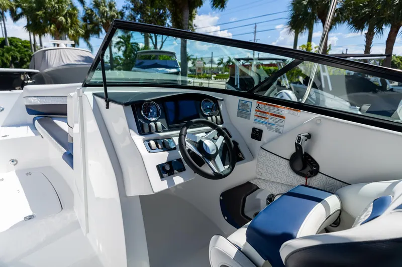 Slide: The Image of 2023 Hurricane SunDeck 2690 OB boat interior with steering wheel and dashboard controls. - 18