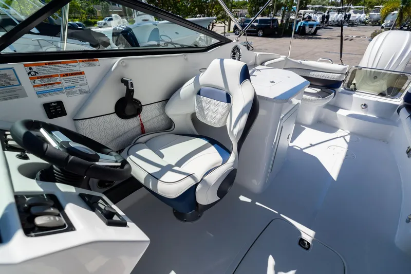 Slide: The Image of 2023 Hurricane SunDeck 2690 OB boat interior with steering wheel and seating area. - 22