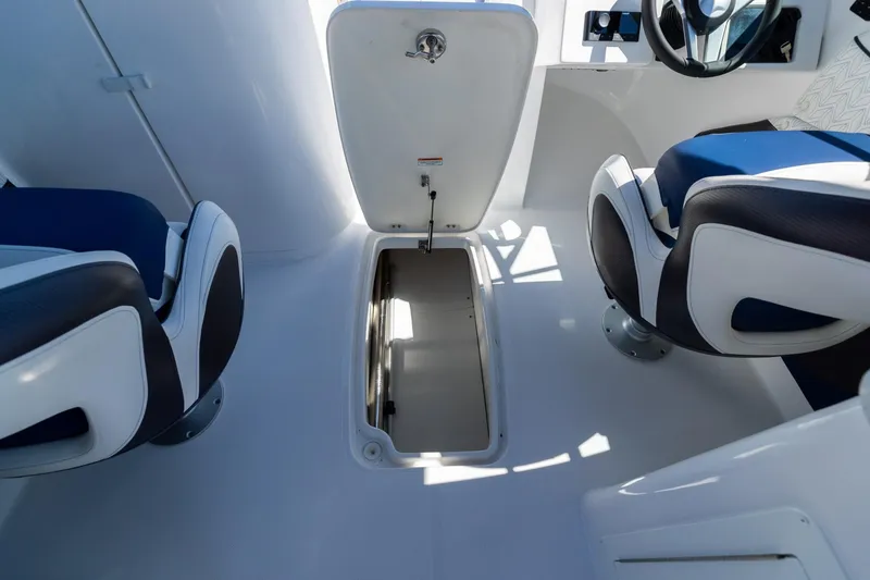 Slide: The Image of 2023 Hurricane SunDeck 2690 OB interior with open storage compartment and seating. - 28