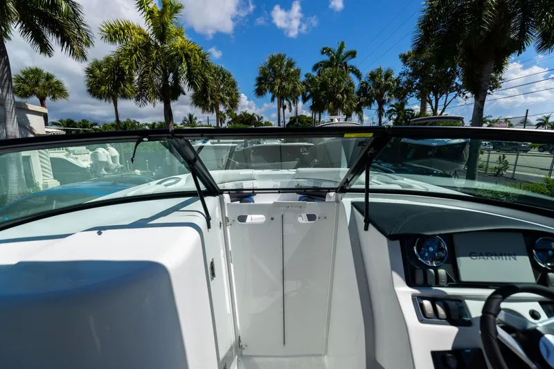 Slide: The Image of 2023 Hurricane SunDeck 2690 OB boat interior with palm trees in the background. - 29