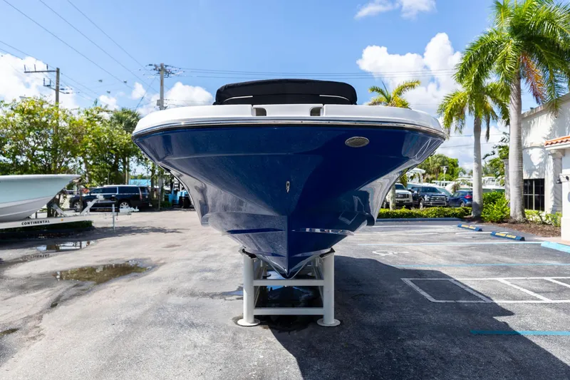 Slide: The Image of 2023 Hurricane SunDeck 2690 OB boat displayed outdoors, front view, blue hull, sunny day. - 3