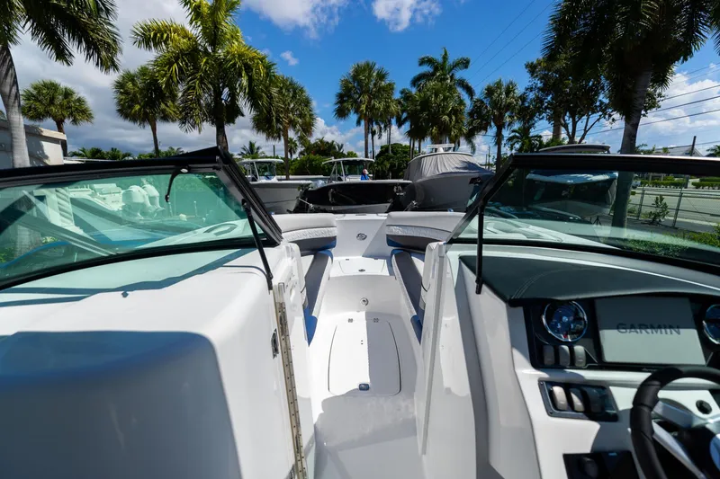 Slide: The Image of 2023 Hurricane SunDeck 2690 OB boat interior with palm trees and blue sky background. - 30