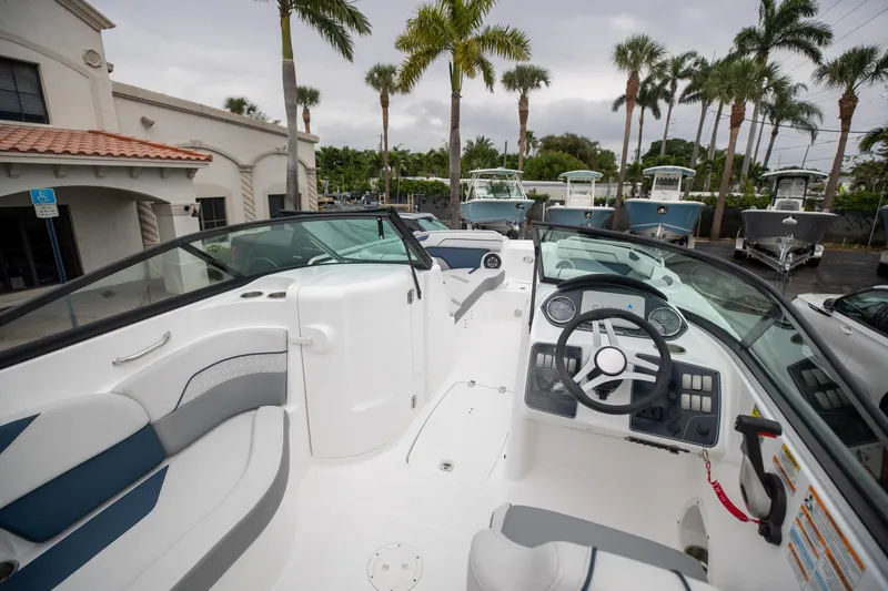 Slide: The Image of 2023 Hurricane SunDeck 2200 OB boat interior with steering wheel, seating, and dashboard. - 18