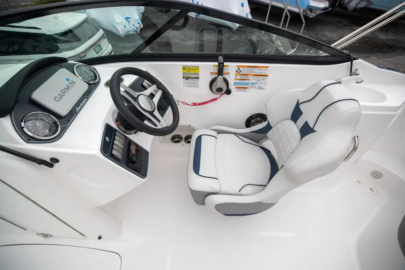 Slide: The Image of 2023 Hurricane SunDeck 2200 OB boat cockpit with Garmin navigation and plush captain's chair. - 24