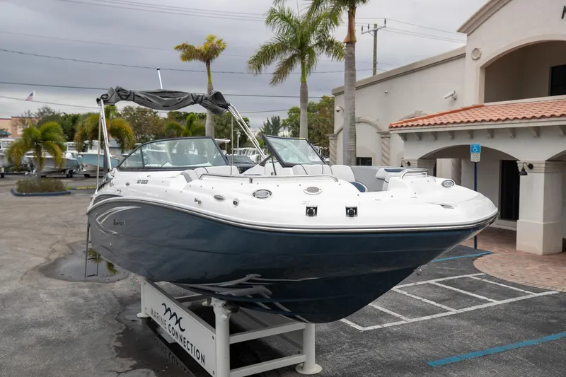 Slide: The Image of 2023 Hurricane SunDeck 2200 OB boat displayed outdoors near palm trees. - 3