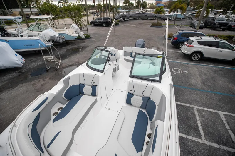 Slide: The Image of 2023 Hurricane SunDeck 2200 OB boat with spacious seating in a marina parking lot. - 30